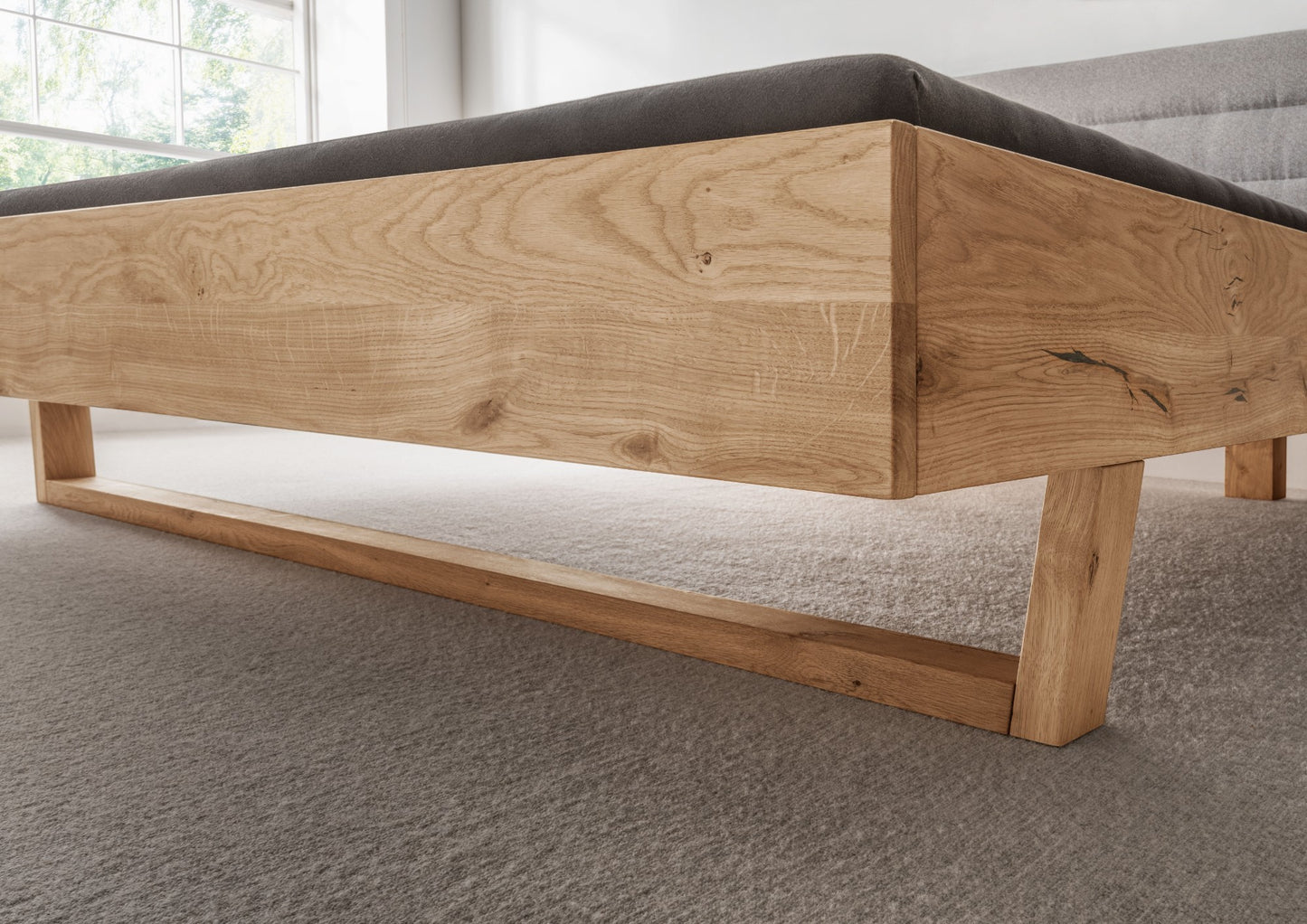 Bett <SchlafGut> aus massiver Wildeiche mit gepolstertem Holzkopfteil