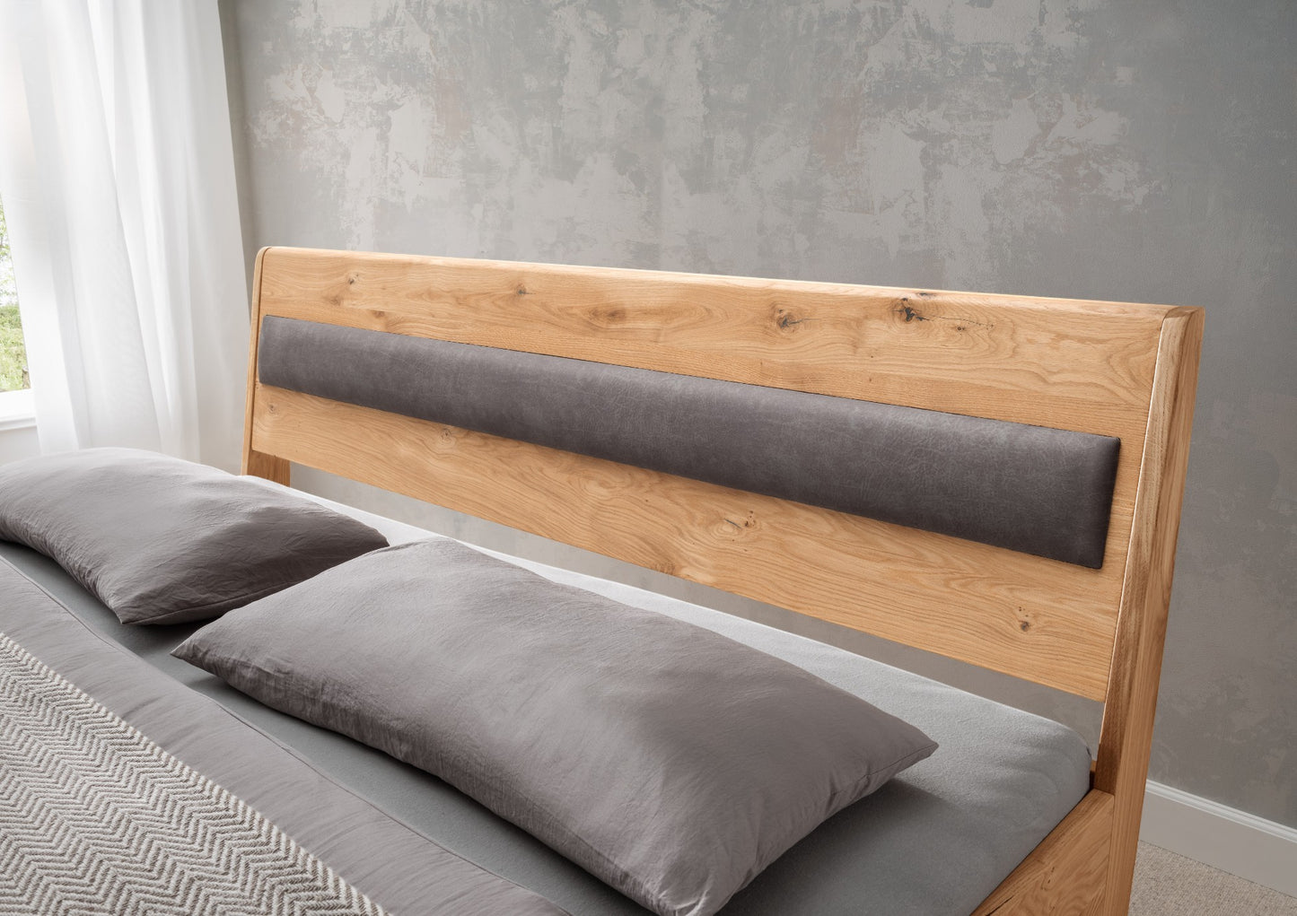 Bett <SchlafGut> aus massiver Wildeiche mit gepolstertem Holzkopfteil